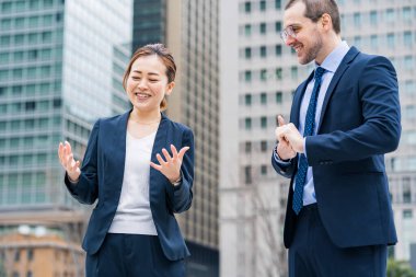 İş ekibi dışarıda rahat bir atmosferde sohbet ediyor.