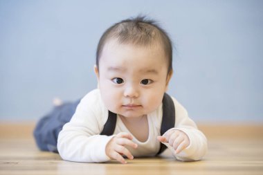 Odanın ahşap zemininde emekleyen Japon bebek.