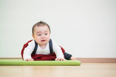 Odanın ahşap zemininde emekleyen Japon bebek.