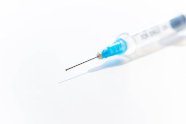 Beyaz kağıda yerleştirilmiş şırınga