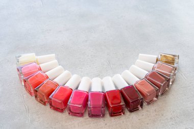 Gri arka planda renkli kırmızı ve pembe oje.