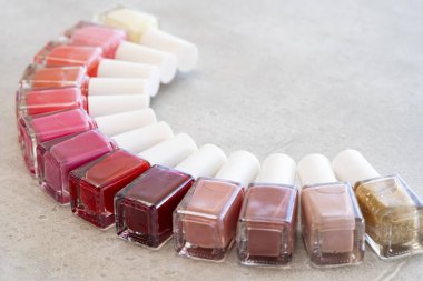 Gri arka planda renkli kırmızı ve pembe oje.