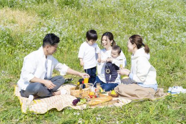 Açık havada piknik yapmayı seven insanlar (3 yetişkin ve 2 çocuk)