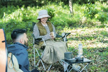 Kadın ve erkek ormanda kamp yapıyor.