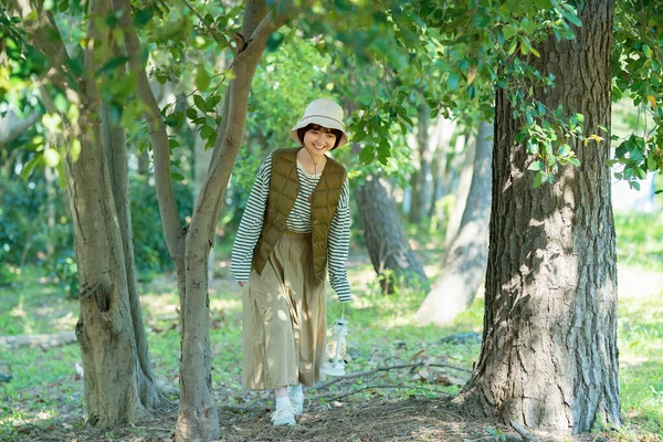 A young woman strolling through a bright forest on fine day