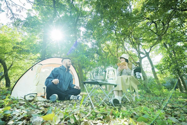 Man and woman enjoying camping in the forest