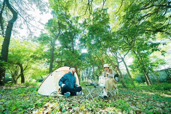 Man and woman enjoying camping in the forest