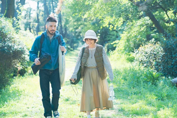 Man and woman heading to the campsite with their luggage