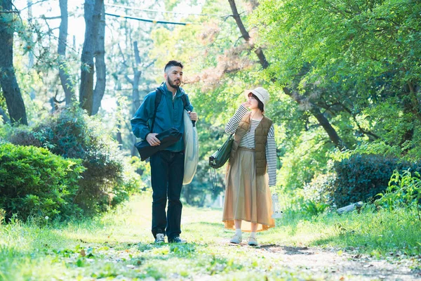 Man and woman heading to the campsite with their luggage