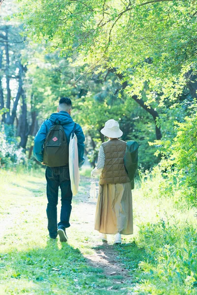 Man and woman heading to the campsite with their luggage