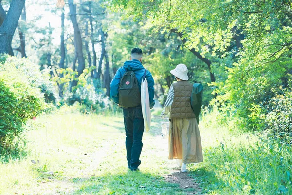 Man and woman heading to the campsite with their luggage