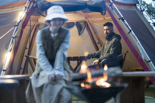 Man and woman enjoying a bonfire in the dark