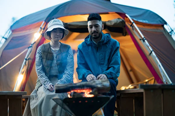 Man and woman enjoying a bonfire in the dark