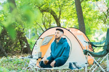 Genç adam güzel bir günde tek başına kamp yapıyor.