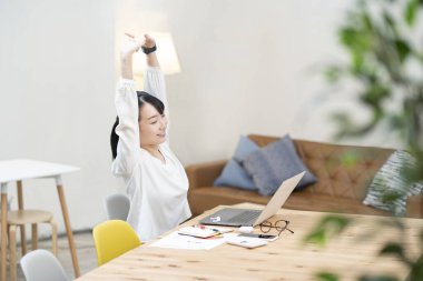 Genç bir kadın sıradan bir yerde iş yerinde geriniyor.