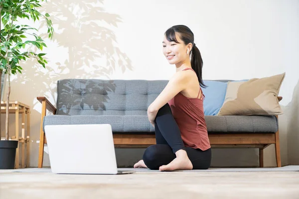 Una Mujer Haciendo Yoga Mientras Mira Pantalla Computadora Habitación — Foto de Stock