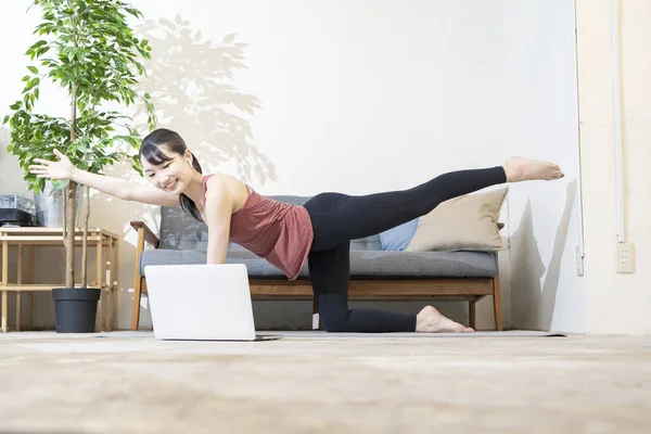 Kvinna Som Gör Yoga Medan Hon Tittar Datorskärmen Rummet — Stockfoto