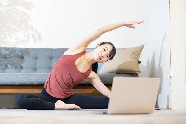 Kvinna Som Gör Yoga Medan Hon Tittar Datorskärmen Rummet — Stockfoto