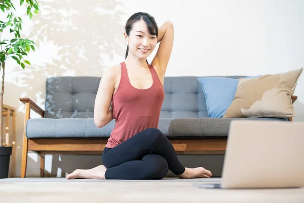 Una Mujer Haciendo Yoga Mientras Mira Pantalla Computadora Habitación —  Fotos de Stock