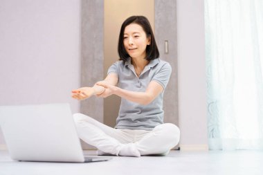 Bilgisayara bakarken hafif egzersiz yapan bir kadın