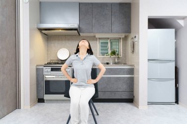 Asyalı orta yaşlı kadın odasında hafif egzersiz yapıyor. 