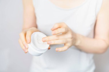 Orta yaşlı kadın güzellik hizmetleri için krem topluyor.