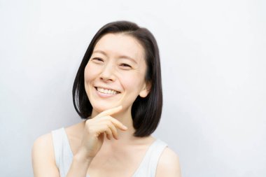 Asyalı kadınlar yüzlerine dokunuyor (40 'lı veya 50' li yaşlarda)) 