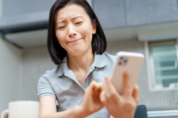 Uma Mulher Olhando Para Smartphone Com Uma Expressão Estressada — Fotografia de Stock