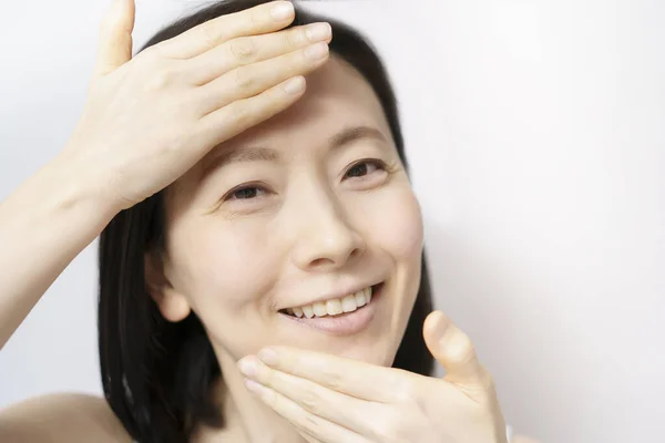 亚洲妇女触摸她们的脸 40或50岁 — 图库照片