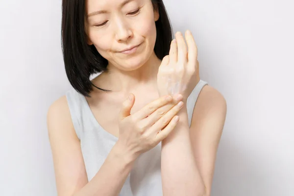 Een Vrouw Die Crème Rug Van Haar Hand Aanbrengt — Stockfoto