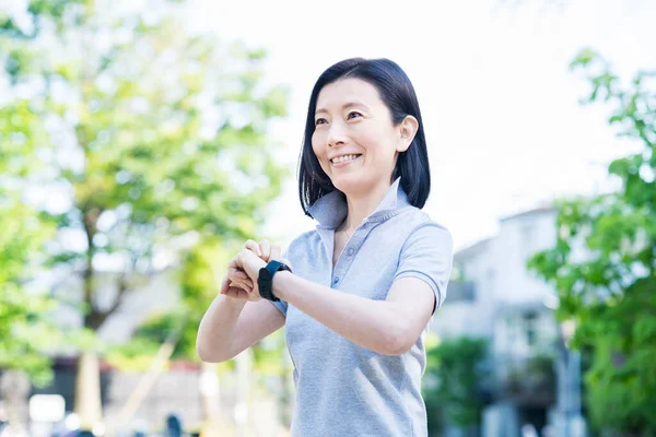 Asiática Mediana Edad Mujer Operando Smartwatch Aire Libre —  Fotos de Stock