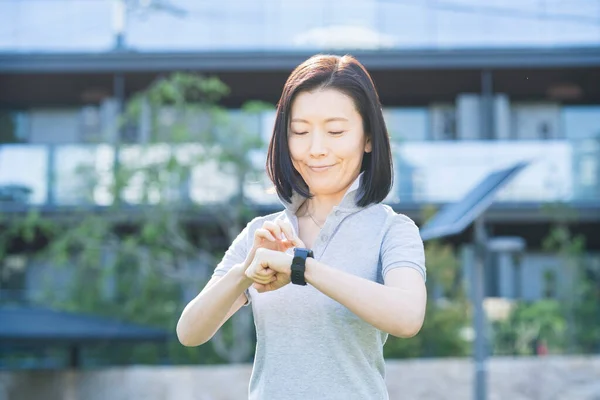 Asiatisk Medelålders Kvinna Som Kör Smartwatch Utomhus — Stockfoto