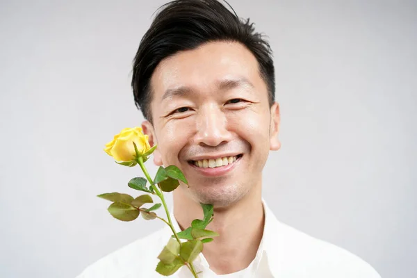 Asiático Hombre Sonriendo Con Amarillo Rosa Flor —  Fotos de Stock