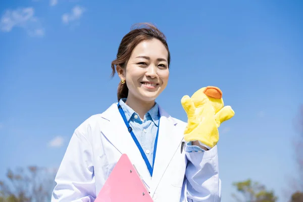 Mujer Asiática Una Bata Laboratorio Sosteniendo Una Muñeca Aire Libre —  Fotos de Stock