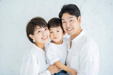 Ebeveynler ve çocuklar bir gülümseme ve desenli beyaz bir arka planla sıraya dizildiler. 