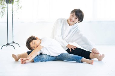 Asyalı anne ve oğlu yoga yapıyor.