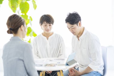 Takım elbiseli bir kadından evin içini anlatan bir açıklama alan bir çift.