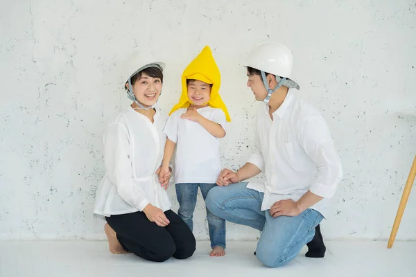 Asian boy wearing disaster prevention hoods and parents wearing helmets