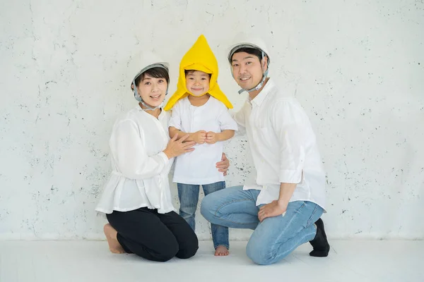 戴防灾帽的亚洲男孩和戴头盔的父母 — 图库照片