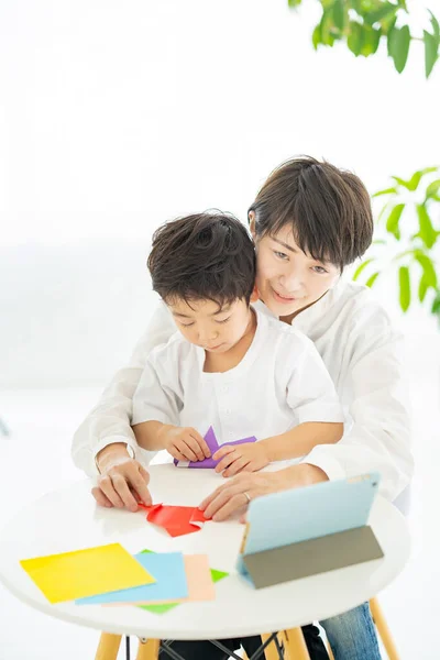 Mãe Filho Fazendo Origami Enquanto Olha Para Tablet — Fotografia de Stock