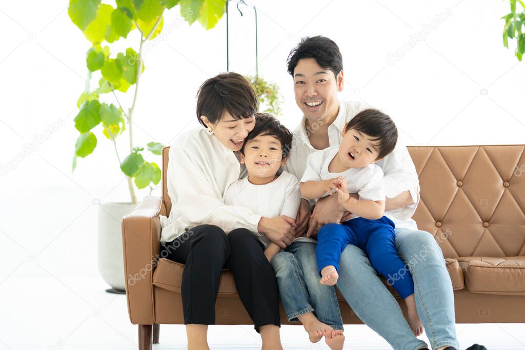 Asian family frolicking on the couch 