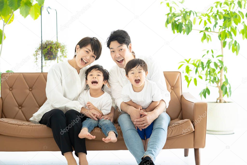 Asian family frolicking on the couch 