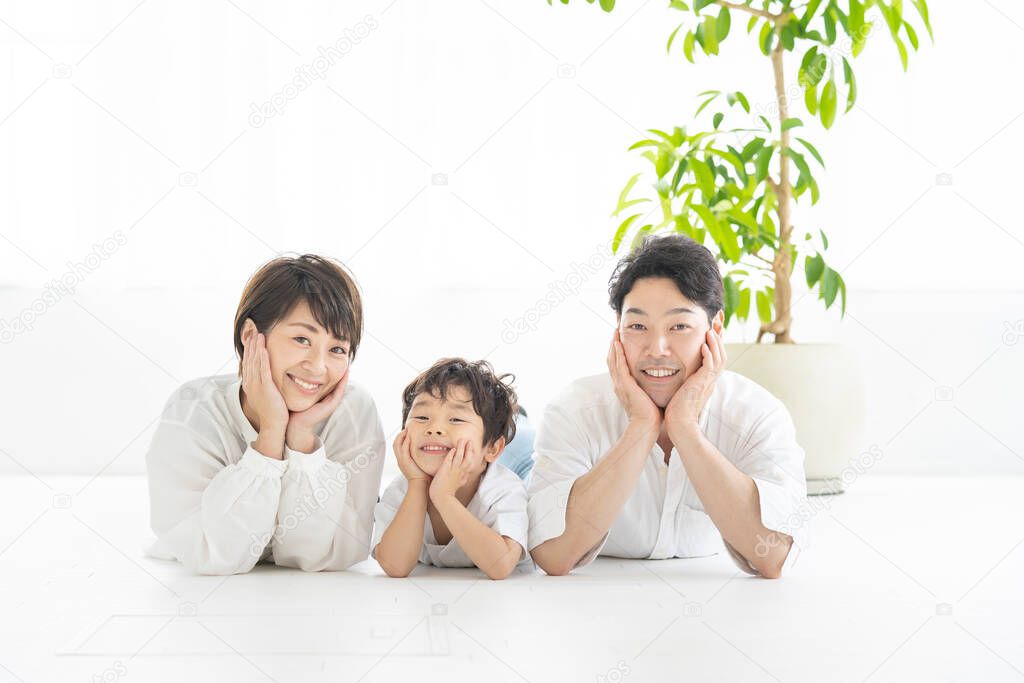 parents and child lying down and taking the same pose