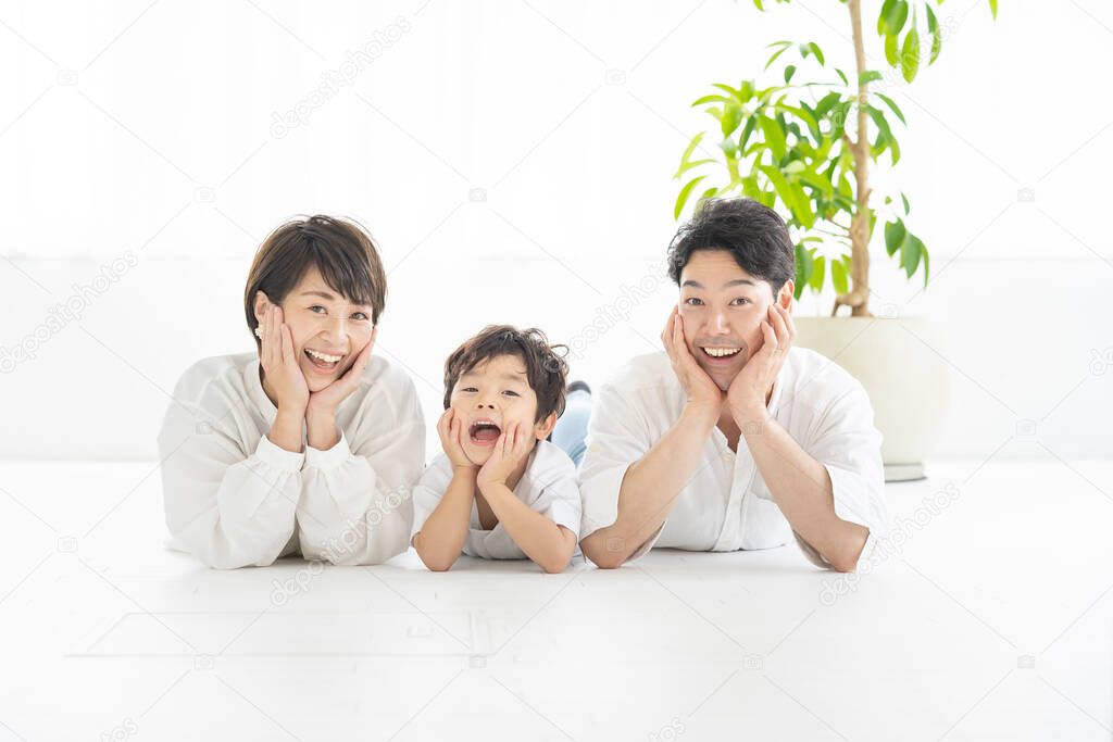 parents and child lying down and taking the same pose