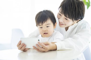 Çocuk ve anne akıllı telefon ekranına deli oluyorlar.