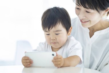 Çocuk ve anne akıllı telefon ekranına deli oluyorlar.