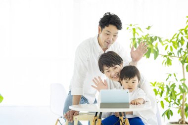 Asyalı ebeveynler ve çocuklar tablet bilgisayar kullanarak internet üzerinden iletişim kuruyorlar