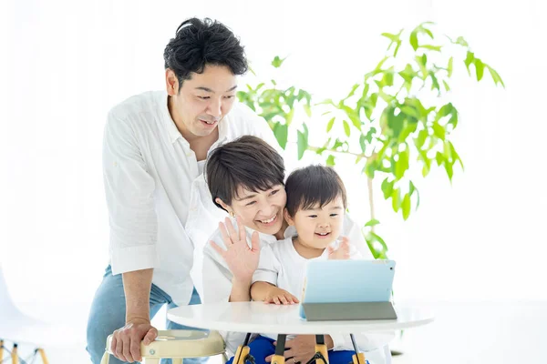 Asian parents and child communicating online using a tablet PC