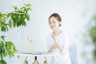  Parlak odada bilgisayarla iletişim kuran bir kadın.