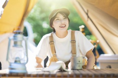 Solo kamp görüntüsü. Çadırda dinlenen genç bir kadın.